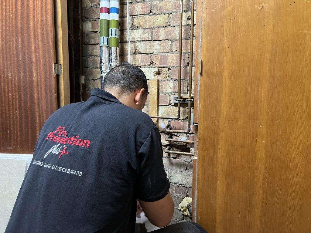 Fire Prevention Operative assessing fire stopping requirements at a university