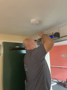 Engineer installing Auto Closer to fire door